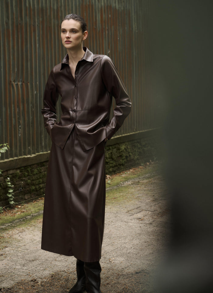 Woman wearing vegan leather blouse and skirt in chocolate color from Japan TKY fall/ winter 2024 collection